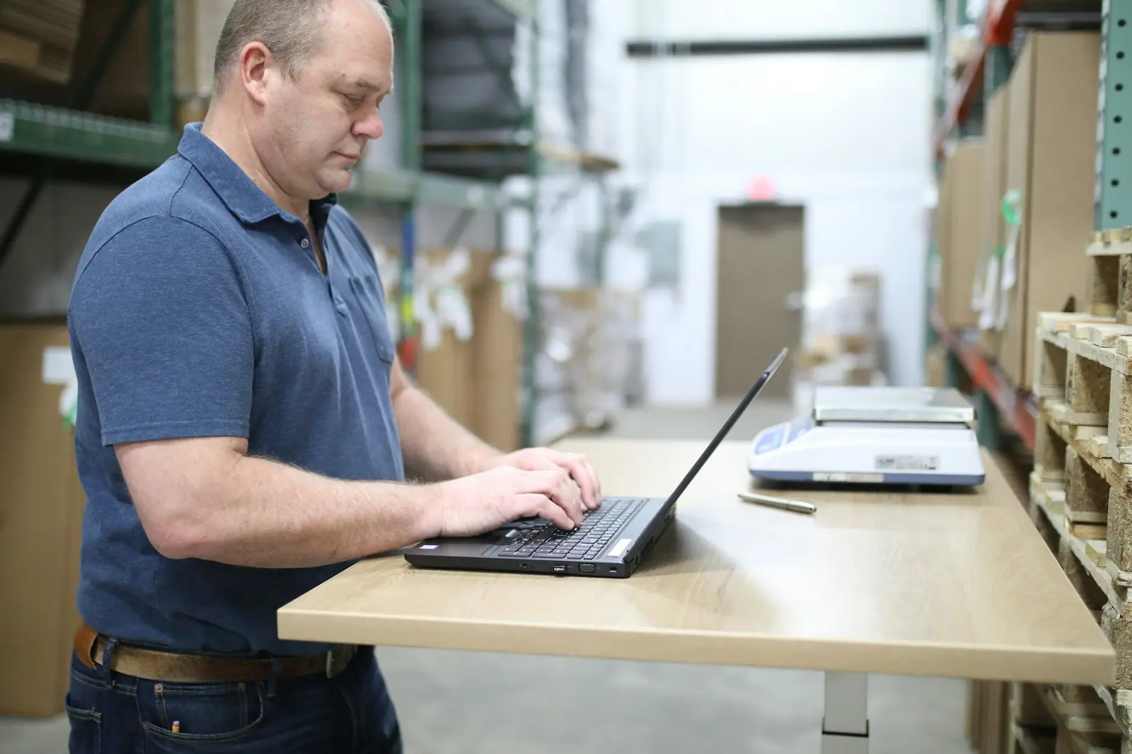 Staff recording cargo data on a laptop inside the warehouse