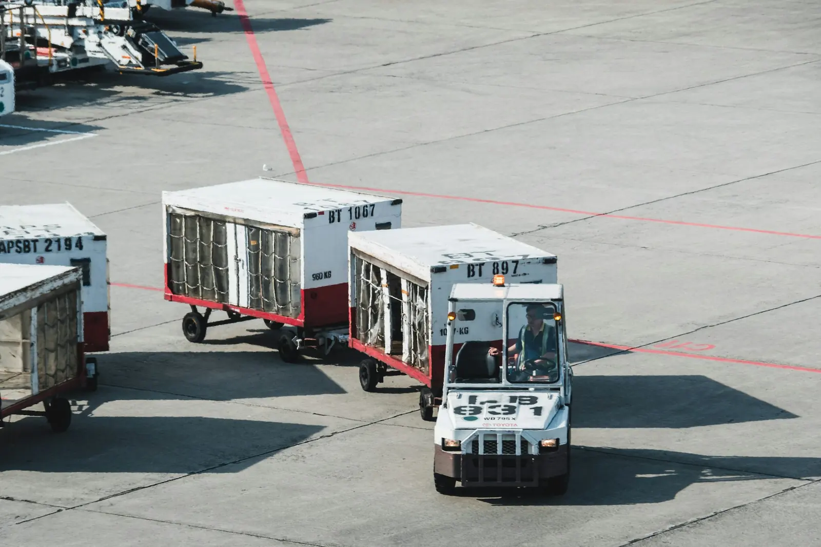 A tractor towing air cargo containers at an airport