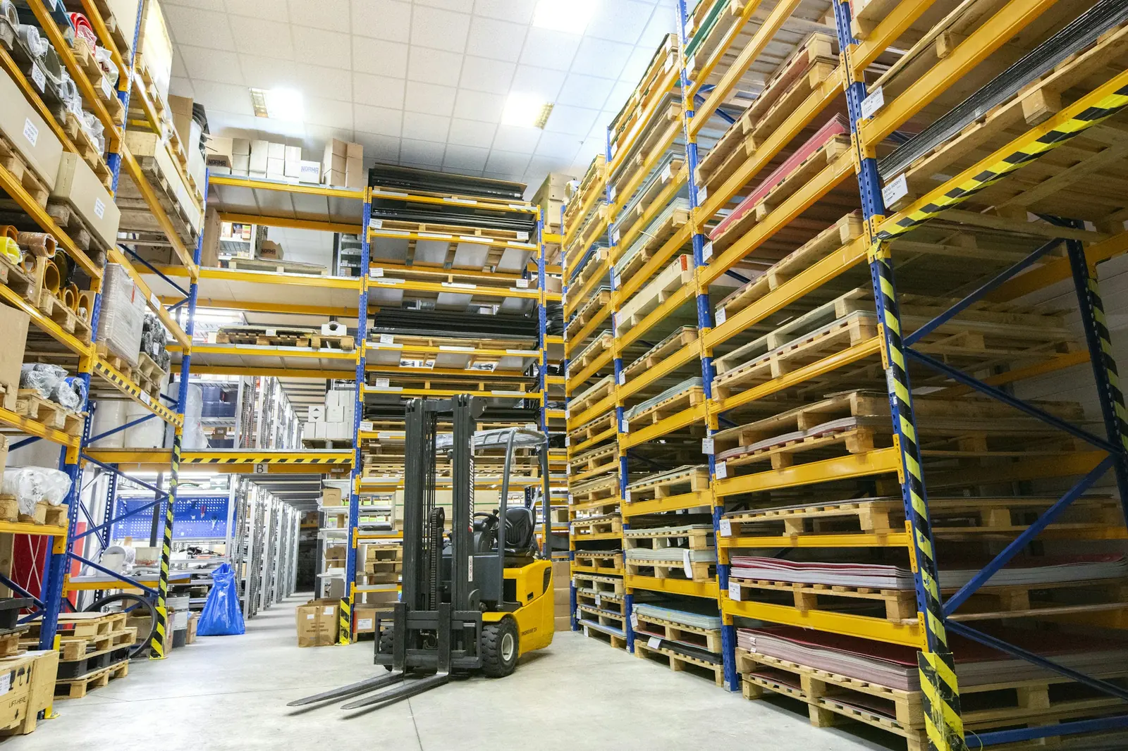 A forklift between warehouse racks